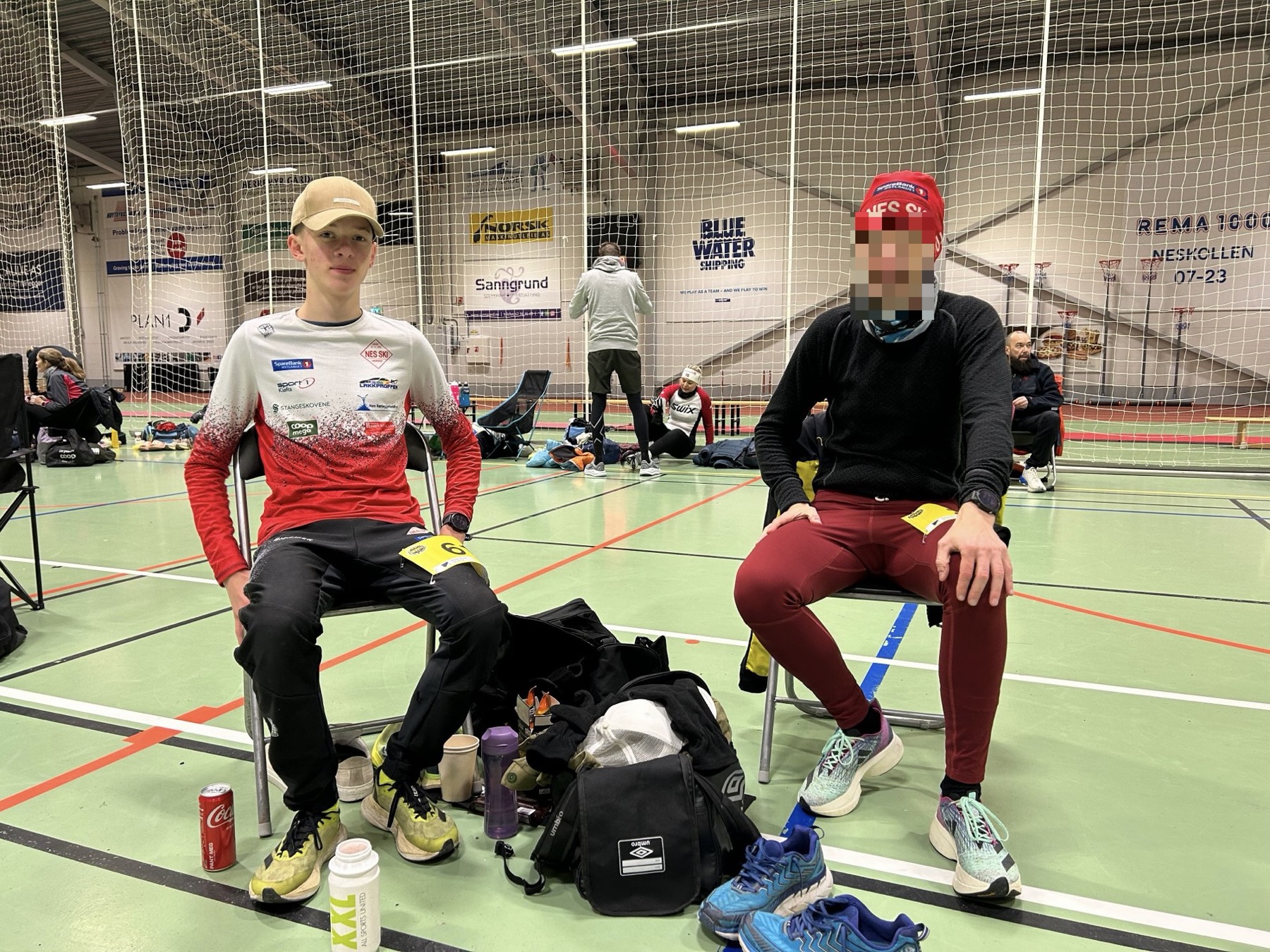 Waiting between races at an indoor venue, in race kit with a number pinned on.